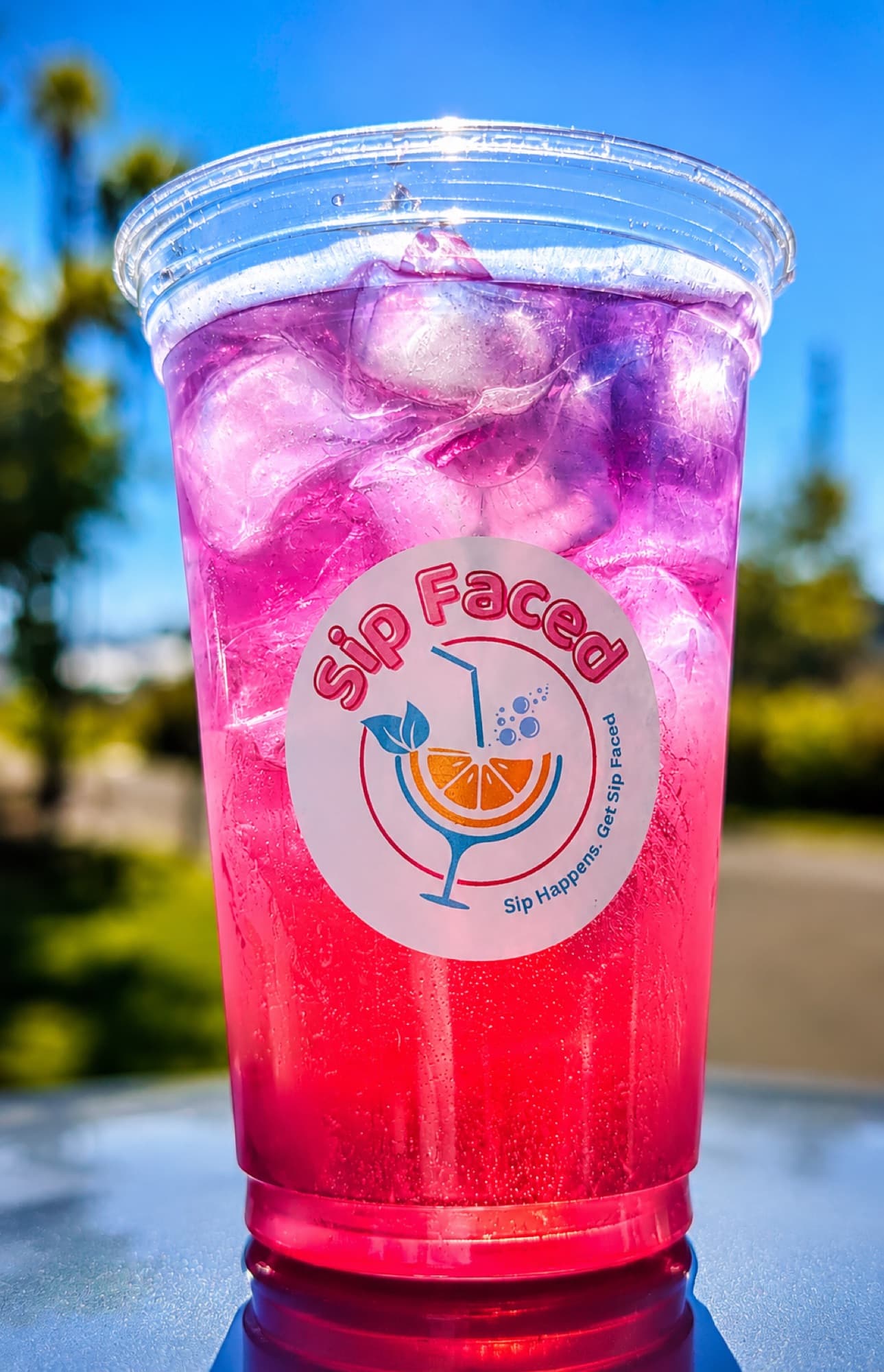 Bright pink-to-purple gradient Sip Faced lemonade in a cup